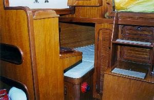 The navigation table and quarter berth is located on the starboard side,
aft. The companionway steps lift and the engine cover lifts off to access the
engine.